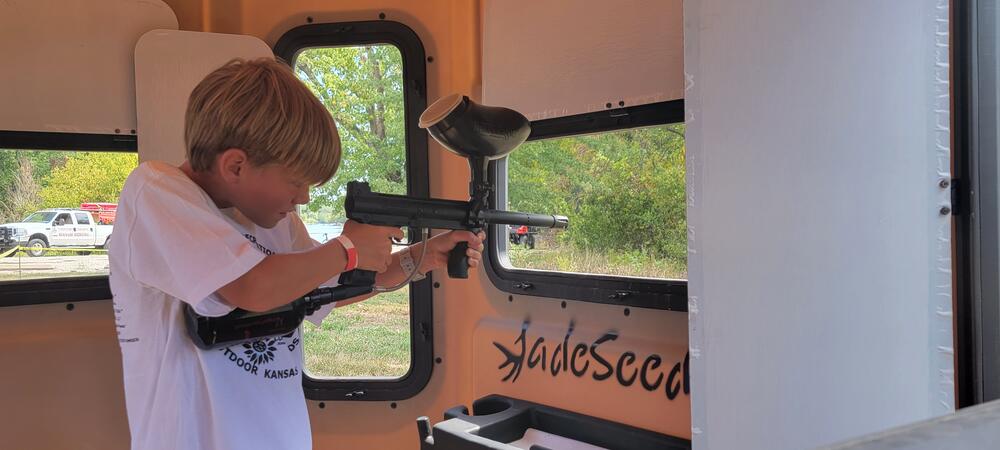 Child Shooting Paintball Gun Out of Hunting Blind Window