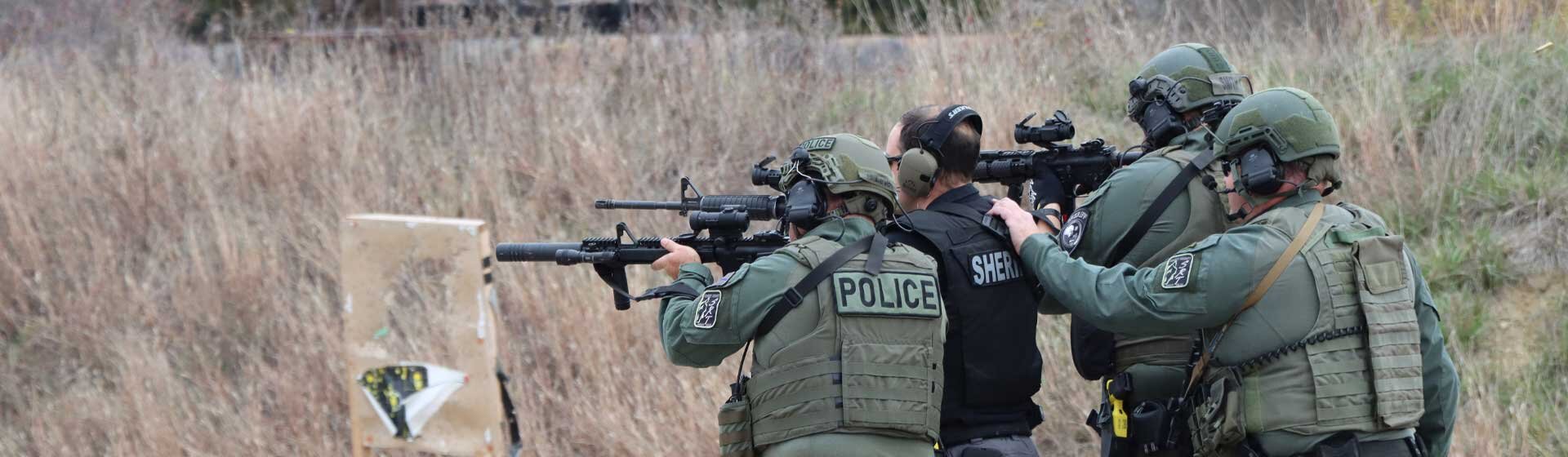 4 offices pointing rifles in a shooting range