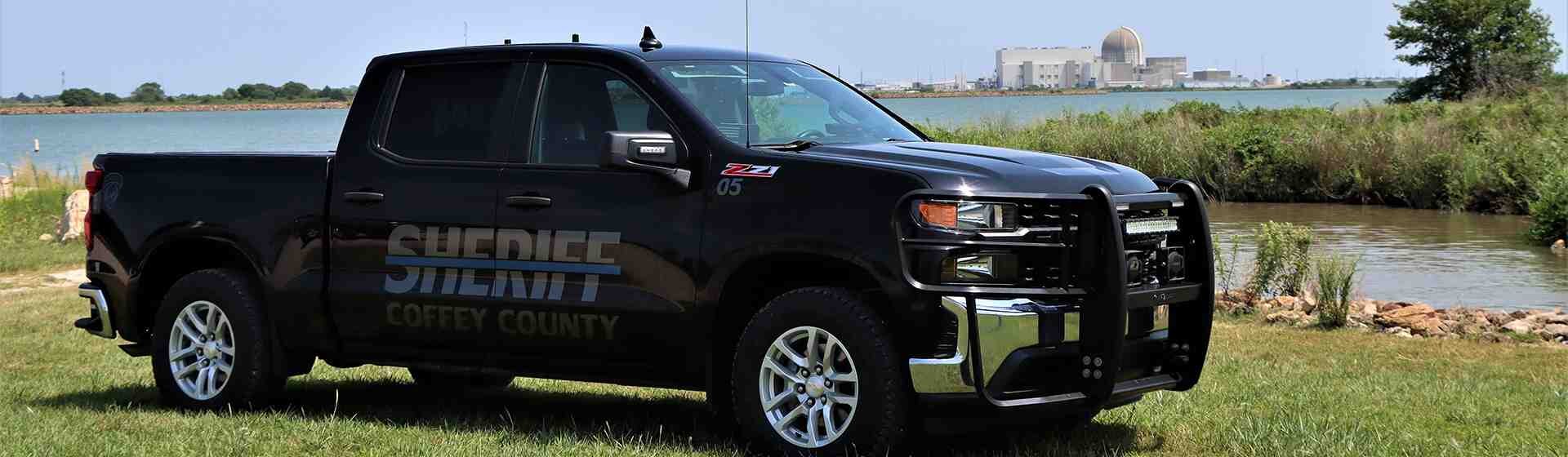Coffey County sheriff vehicle parked next to a lake.